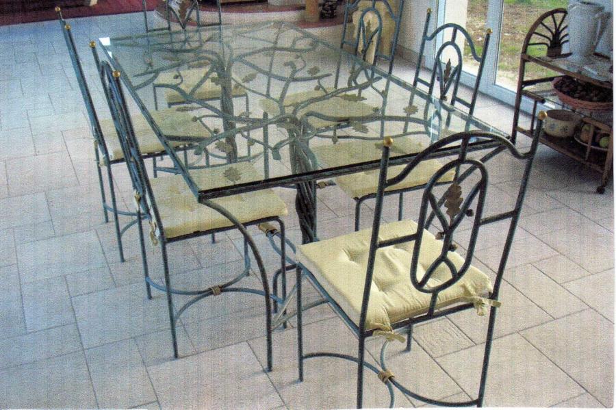 Table et chaises en verre et fer forgé d'inspiration végétale